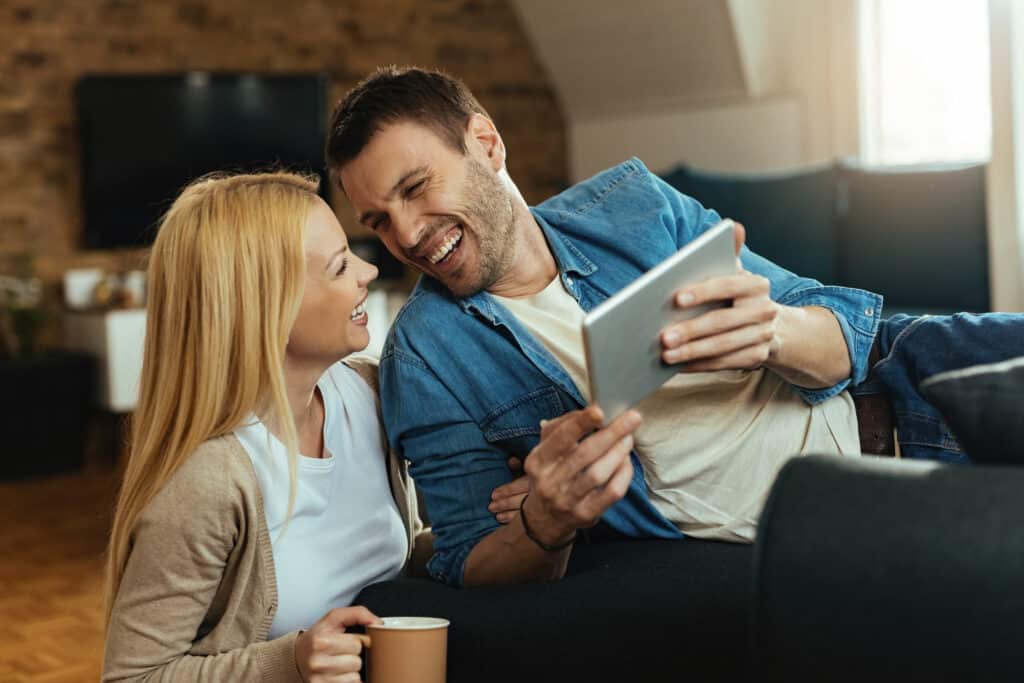 Happy couple laughing together after resolving their conflict, illustrating progress from ' Why does my wife yell at me ' to building trust and joy